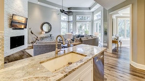 A modern kitchen with a marble countertop, a built-in sink, and a ceiling fan. - 37 St. George - 5 minute walk to the beach! (Hilton Head Island)