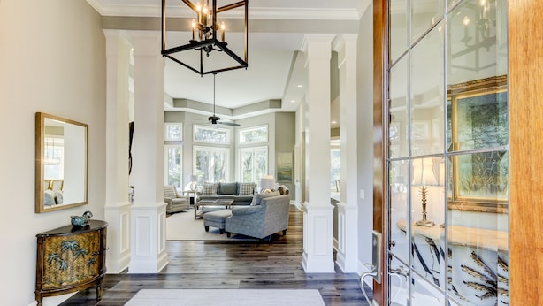 A spacious hallway with a large mirror, a decorative cabinet, and a modern chandelier. - 37 St. George - 5 minute walk to the beach! (Hilton Head Island)