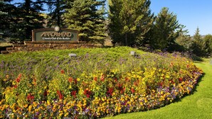 A sign for Arrowhead Country Club of the Rockies surrounded by a colorful flower garden. - Amazing Arrowhead condo, POOL is OPEN! Walk to slopes, ski locker!! (Edwards)