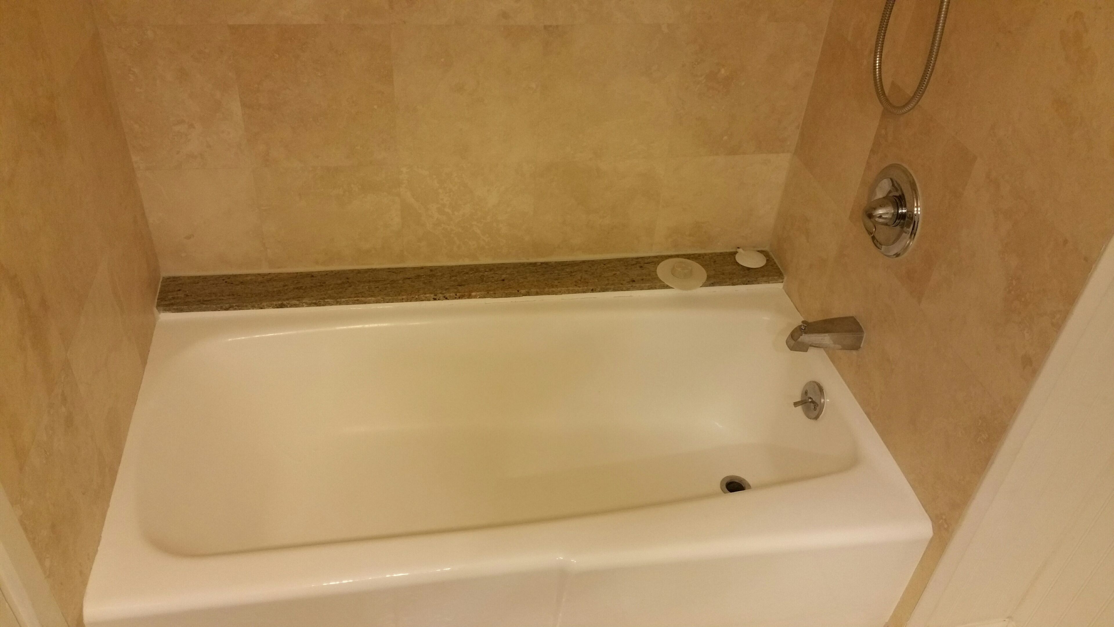 A standard white bathtub with a showerhead and a faucet.