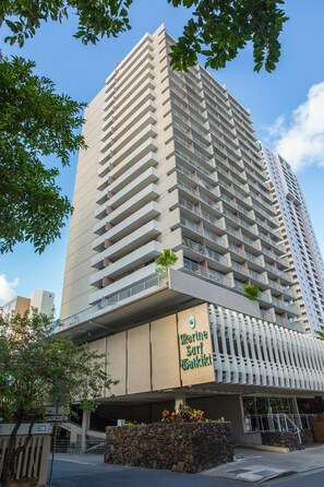 A high-rise hotel with multiple balconies and a sign indicating 'Park Inn Suite Waikiki.'