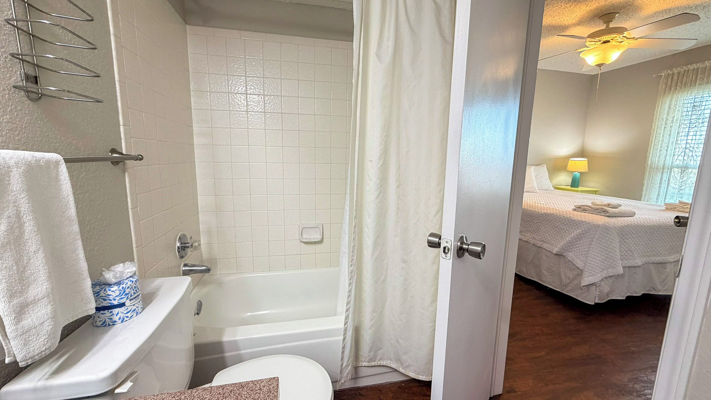 A bathroom with a bathtub, toilet, and a shower curtain.