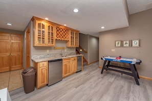Enjoy cooking and leisure time in this kitchen with a dishwasher, foosball table, and marble countertop.