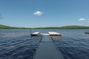Een houten steiger die uitsteekt in kalm water, met een heldere lucht erboven.