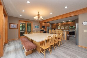 A spacious kitchen with wooden cabinets, a large island with seating, and modern appliances.