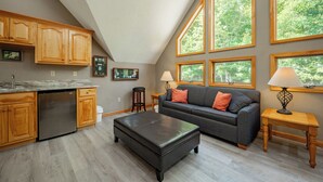 A kitchen with wooden cabinets, a built-in dishwasher, and a large window overlooking greenery. - Tranquil Lakefront w/ Twin Hot Tubs & Dock (Oakland)