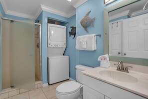 A bathroom with a white toilet, a white sink, and a glass shower enclosure.