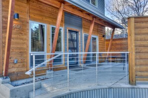 Une cabane en bois avec une rambarde en métal, un escalier en béton et le numéro « 405 » peint sur le mur.