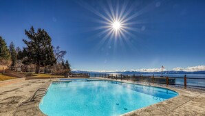 A swimming pool with a clear view of mountains and a flag in the background.
