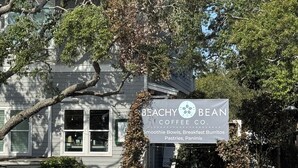 Een bord voor Beachy Bean Coffee Co. met menu-items zoals smoothie bowls, ontbijtburgers, gebak en panini's.