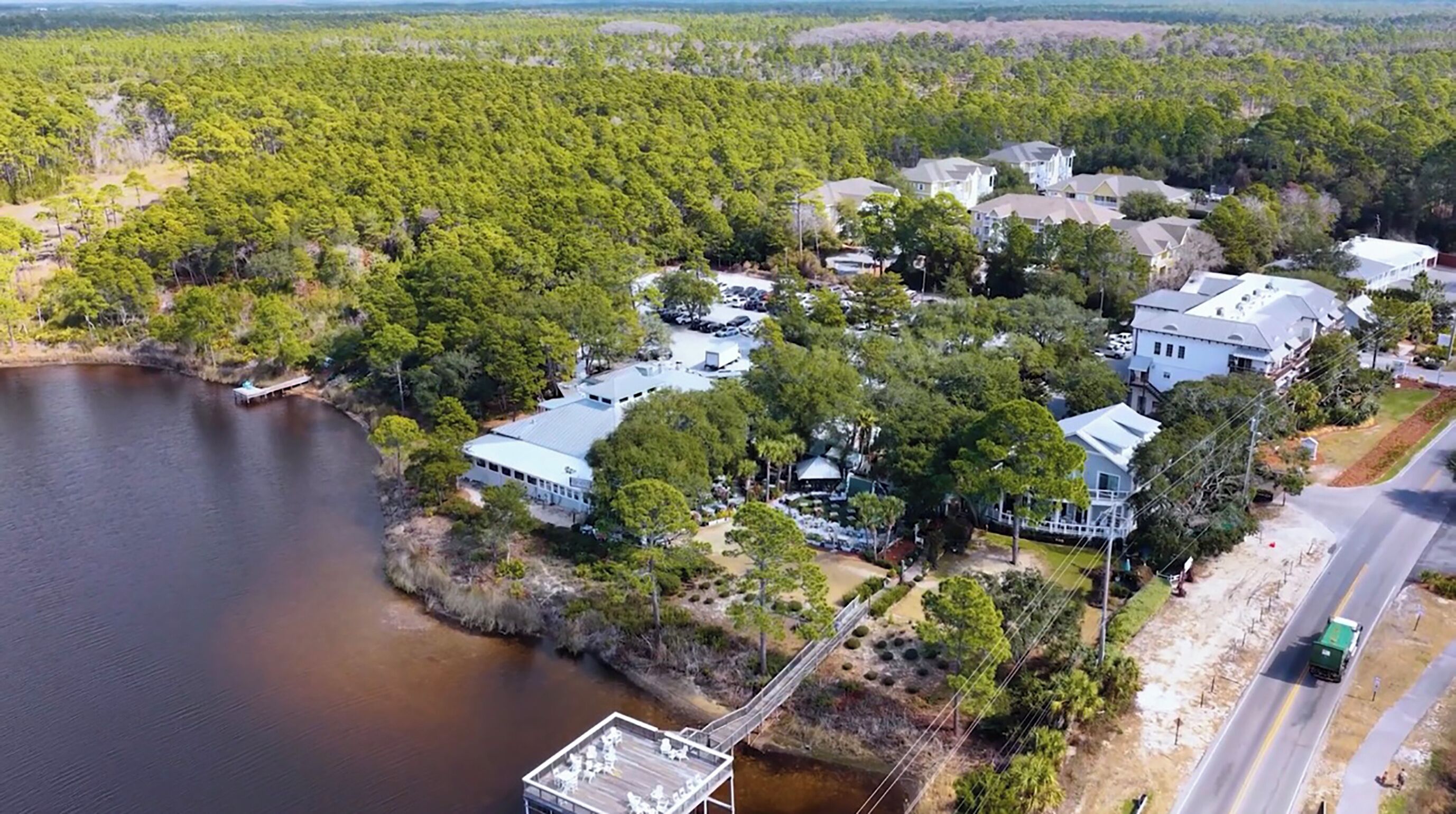An aerial view of a residential area with houses, a dock, and a road.