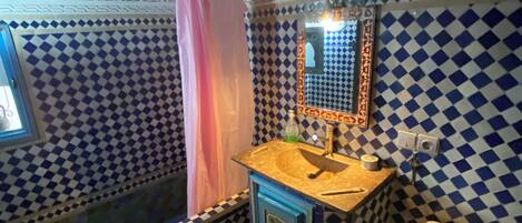 A bathroom with a checkered tile pattern, a sink with a mirror, and a toilet.