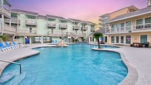 Une piscine entourée d’immeubles à plusieurs étages, dotés de balcons et d’espaces de détente en plein air.