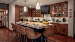 A modern kitchen with a central island, stainless steel appliances, and wooden cabinetry.