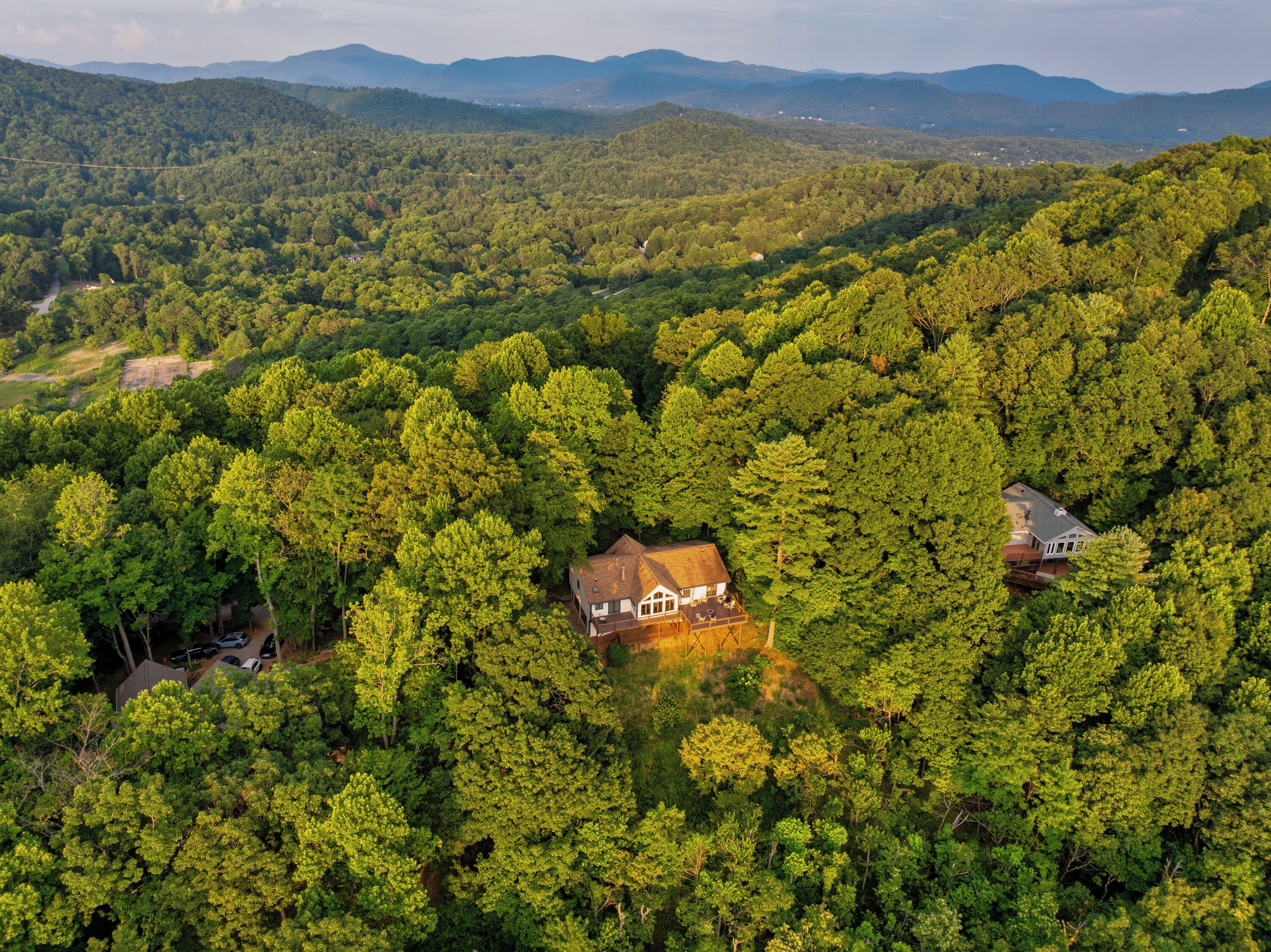 Une maison entourée d’une forêt dense, offrant une vue dégagée sur les collines environnantes.