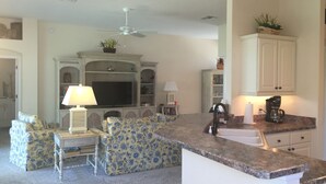 A living room with a TV, sofa, and coffee maker.