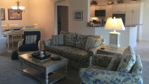 A living room with a sofa set, a coffee table, and a television.