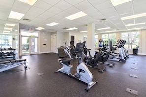 A gym with various exercise equipment, including treadmills and stationary bikes, and a weight rack. - Tile floors, spacious beachfront condo w/private balcony! (Destin)