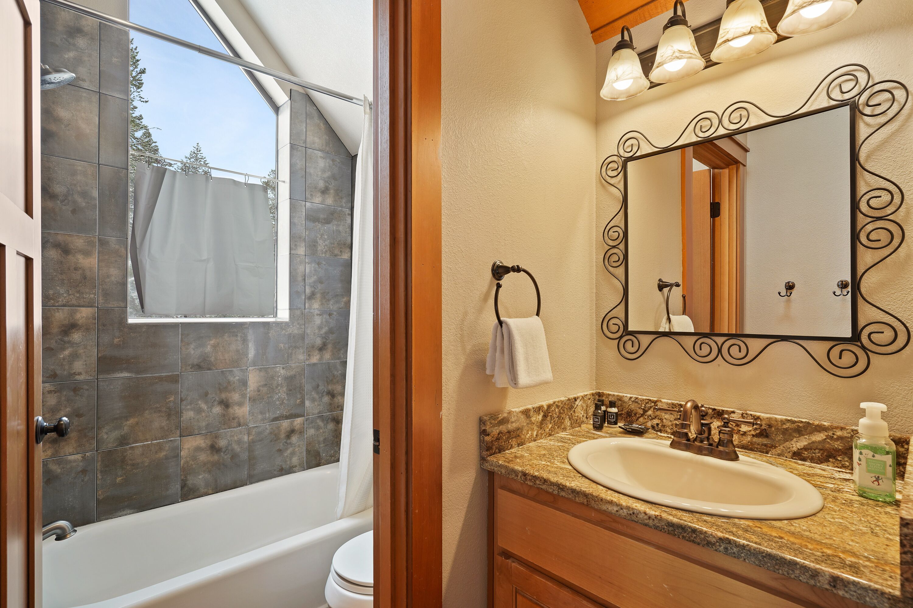 Une salle de bain avec une baignoire, un lavabo et un miroir.