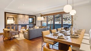 A modern dining area with a wooden table set for a meal, a sofa, and a fireplace. - New Upgrades | One Steamboat Place 703 Sugar Loaf (Steamboat Springs)