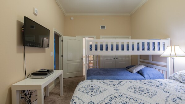 A bedroom with bunk beds, a desk with a television, and a lamp. - Oasis, Formerly Phoenix West II, Beach front, Lazy River/Water Slide!! (Orange Beach)
