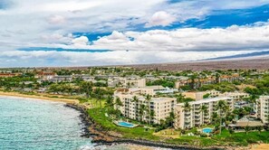 Un resort costero con varias construcciones, una playa y cielo despejado.