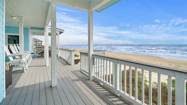 A wooden deck with white railings overlooking a beach. - Front Row | Pet-Friendly, Stunning Beach Views (Galveston)