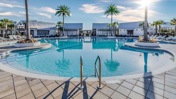 A pool area with two separate pools, palm trees, and lounge chairs. - "Lucky Old Sun" - Prominence - 3BR / 2.5 BA - Sleeps 9 - 6 Passenger Golf Cart (Santa Rosa Beach)