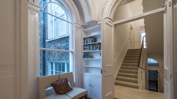 A library with bookshelves, a bench, and a staircase. - The Patrick Kavanagh Suite - hiphipstay (Dublin)