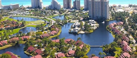 A resort with multiple buildings, a central water body, and surrounding greenery.