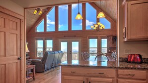 A spacious kitchen with wooden cabinets, a dining area with a view, and a ceiling fan. - Ski-In Views & Hot Tub⛷️ Black Bear Lodge + 8 mins to Hatley Pointe (Mars Hill)