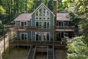 A two-story house with a balcony, a fireplace, and a deck. - Luxury Lakefront Escape w/ Sauna & Hot Tub (McHenry)