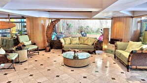 A spacious lobby with a high ceiling, a central round coffee table, and a seating area with sofas and chairs. - Bamboo Hotel - Privately owned Queen Studio - Balcony, Steps to Waikiki Beach (Waikiki)