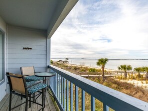A balcony with a view of the beach and ocean.