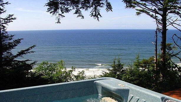Uma banheira de hidromassagem com vista para o oceano e a praia.