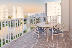 Enjoy a serene river view from this balcony with a table and chairs.