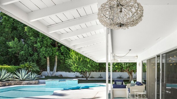 A modern outdoor patio with a pool, seating areas, and a pergola with a decorative ceiling light. - Regency Modern - Indian Canyons Hollywood Regency! (Palm Springs)