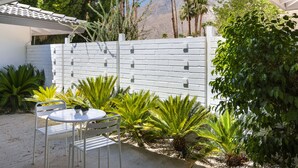A patio with a white fence, palm trees, and a view of mountains. - Regency Modern - Indian Canyons Hollywood Regency! (Palm Springs)