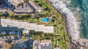 An aerial view of a coastal property with a swimming pool, parking area, and beachfront. - Oceanview Oasis Walk to Shops & Dining: Kamaole Nalu #303 Convenience & Charm! (Kihei)