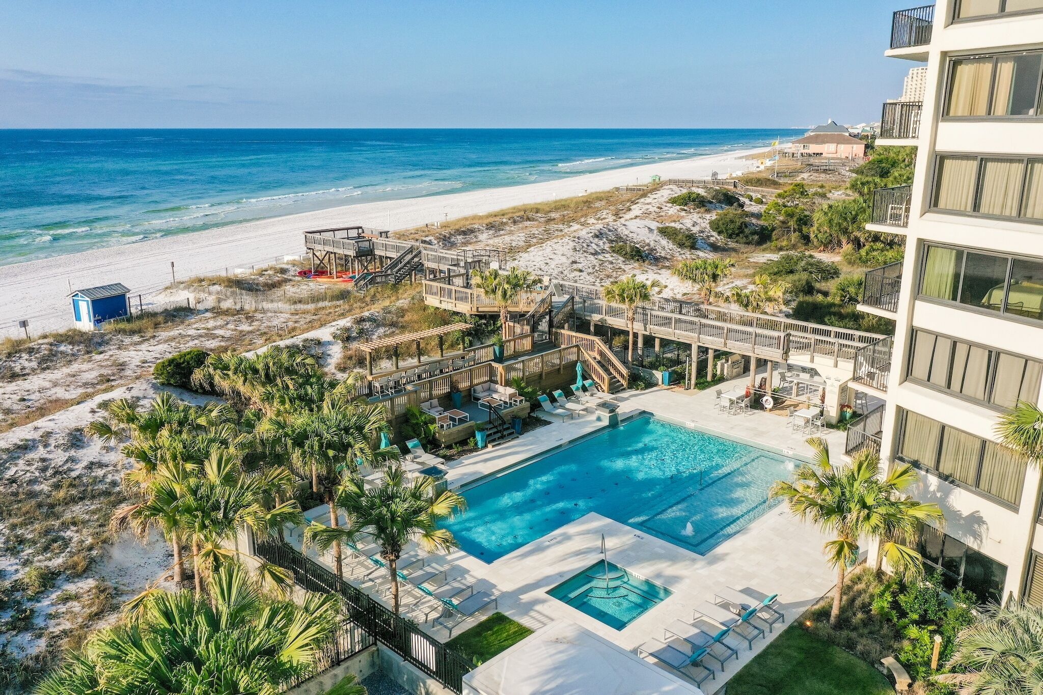 A resort with a pool, beach access, and a view of the ocean.