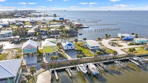 A coastal residential area with houses, docks, and boats. - Tortuga Bay | 2BR/1BA Waterfront Home | Pet-friendly Fort Morgan Retreat (Gulf Shores)