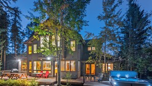 Una casa moderna de dos pisos con un balcón, mobiliario exterior y un jacuzzi.