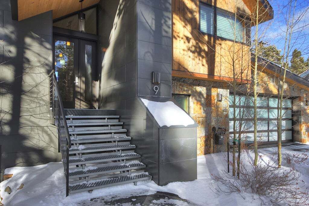 A modern building with a staircase leading to a door marked with the number 9.