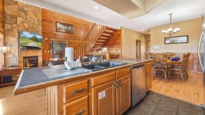 A spacious kitchen with a large island, wooden cabinetry, and a stone accent wall.