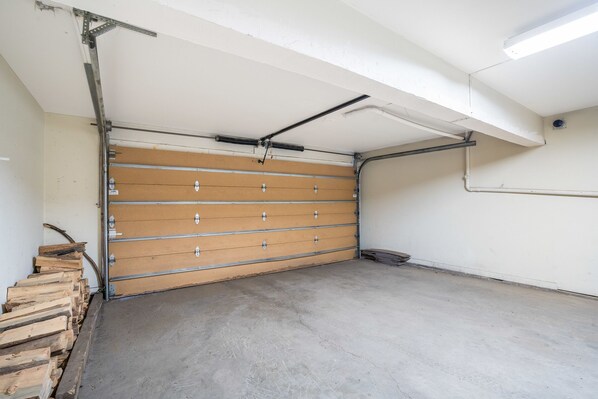 Un garaje con piso de concreto y puerta de madera.