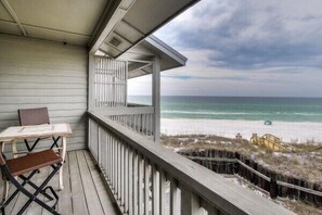 A wooden deck with a table and chairs, overlooking a beach with a wooden walkway and a lifeguard tower. - Walton Dunes unit 2 2bed 2.5B, Seagrove, GulfView (Santa Rosa Beach)
