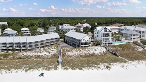 Ett hotell vid kusten med flera byggnader, en gångväg som leder till stranden och ett poolområde.