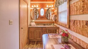 A wooden bathroom with a vanity, mirrors, and a sink.