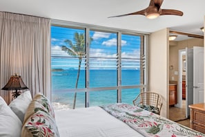 Ein Schlafzimmer mit einem großen Fenster und Blick aufs Meer.