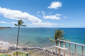 A coastal view with a clear sky, a beach, and a staircase leading down to the shore. - Dazzling Oceanfront Views: Kamaole Nalu 606 - Absolutely Dreamy End condo! (Kihei, Maui)
